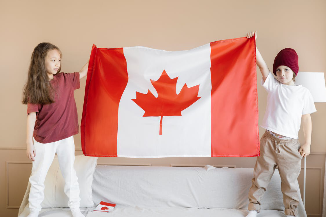  Two kids holding up a Canadian flag
