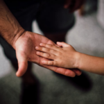 Nanda & Associate Lawyers Canada - A child’s hand in an adult’s hand