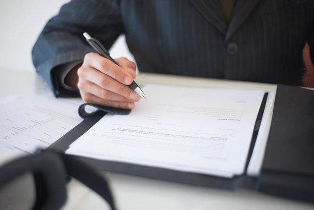 An immigration lawyer filling an entrepreneur application form for their client