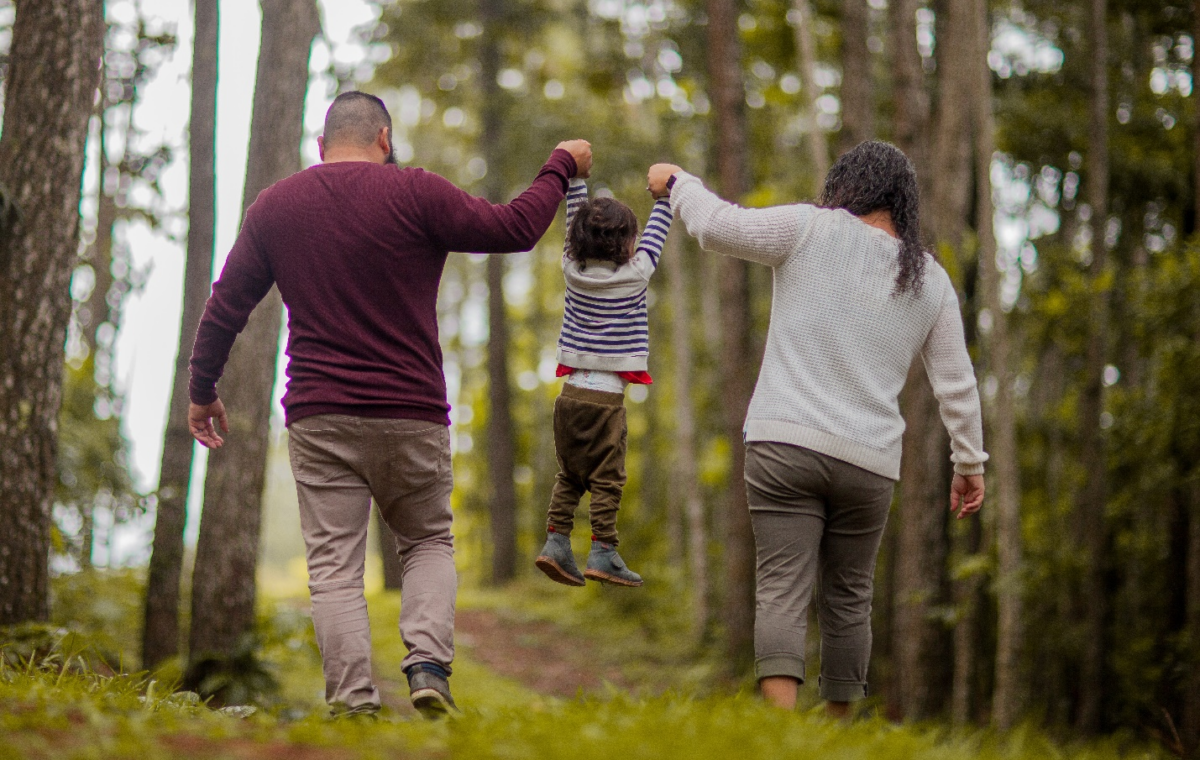 Parents picking up their toddler.