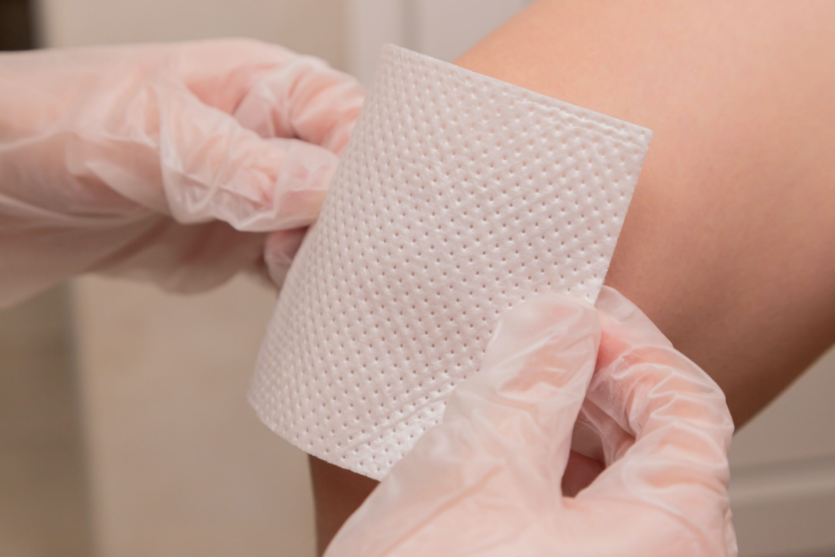 Doctor bandaging a knee.