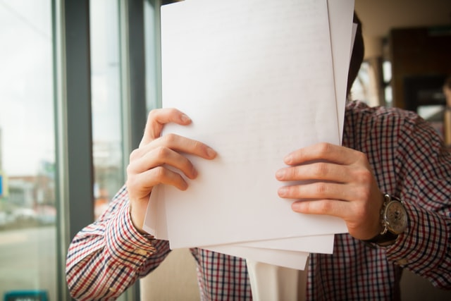 A person holding papers in hands