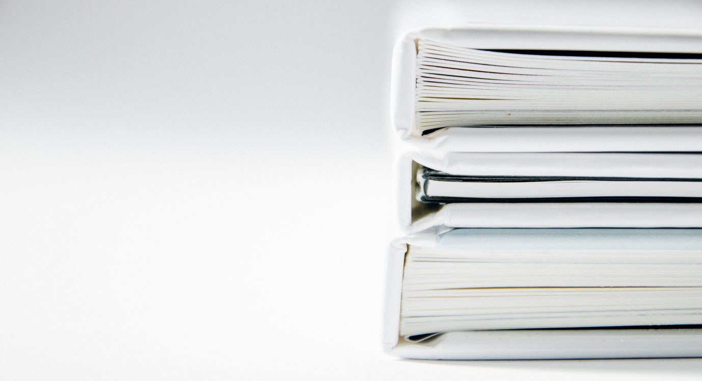 Three white leather folders stacked on top of each other