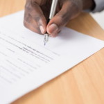 Nanda & Associate Lawyers Canada - A person signing a form