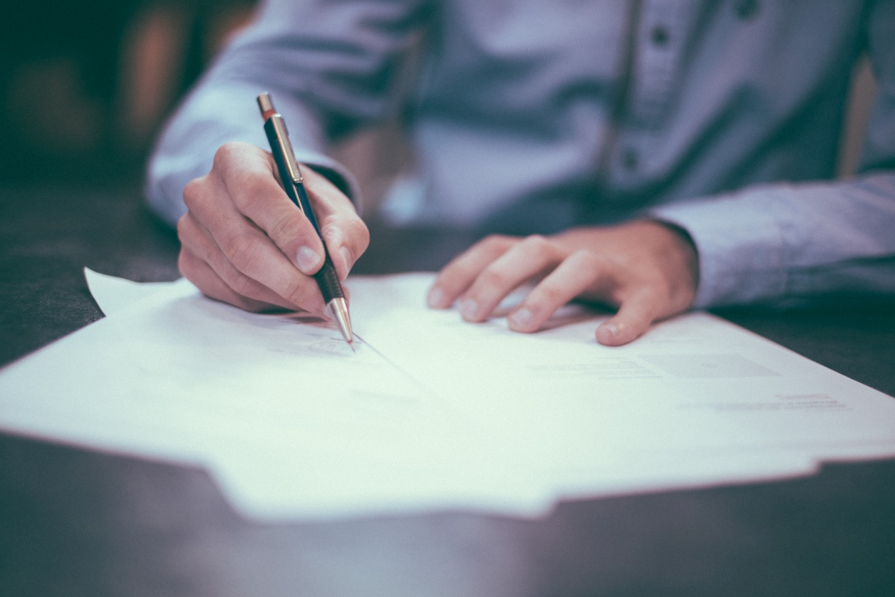 Nanda & Associate Lawyers Canada - A man signing a document