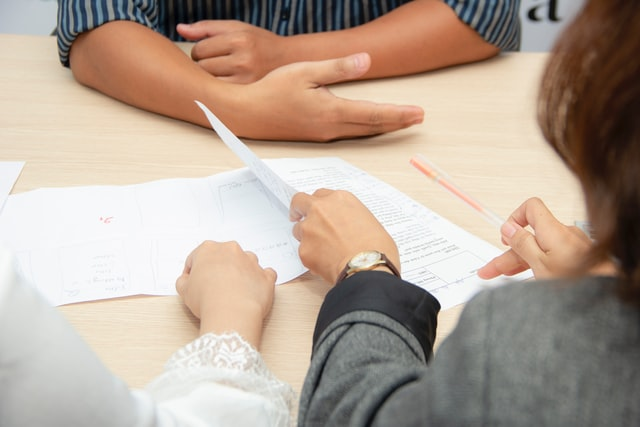 An immigration lawyer helping a client fill spousal sponsorship form