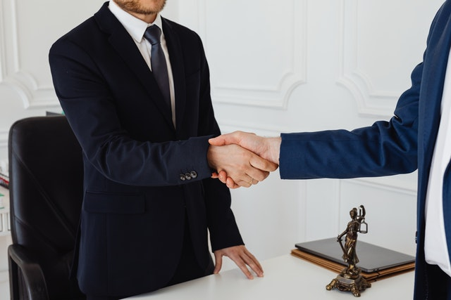 A lawyer shaking hands with a client after a successful divorce settlement