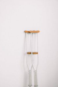  White crutches in front of a wall. 