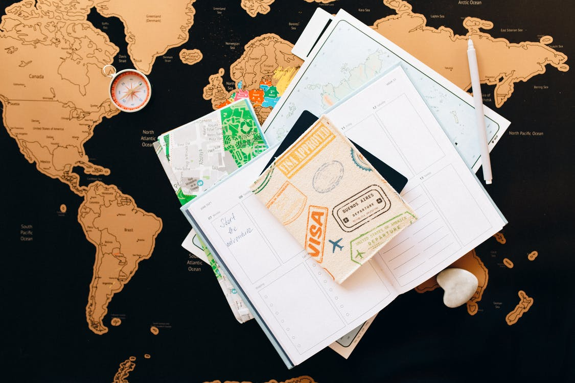 Nanda & Associate Lawyers Canada - A world map with a notebook and a passport
