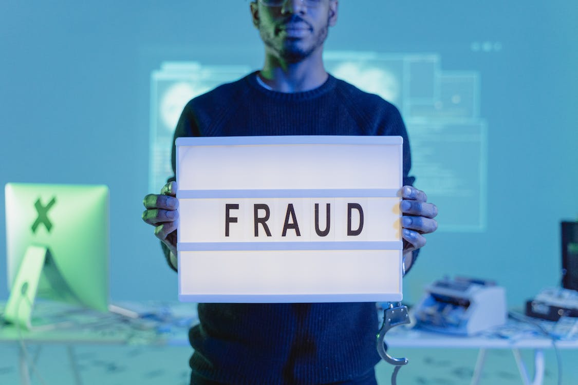 Nanda & Associate Lawyers Canada - Person holding a board saying fraud