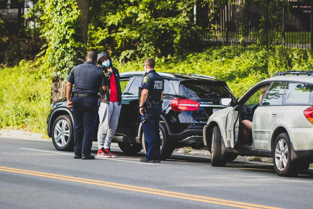 Police officers standing with a car crash victim