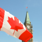 Nanda & Associate Lawyers Canada - Canadian flag in front of clock tower.
