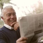 Nanda & Associate Lawyers Canada - A senior citizen smiling while reading the newspaper