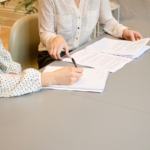 Nanda & Associate Lawyers Canada - A person signing a contract while another person reviews it