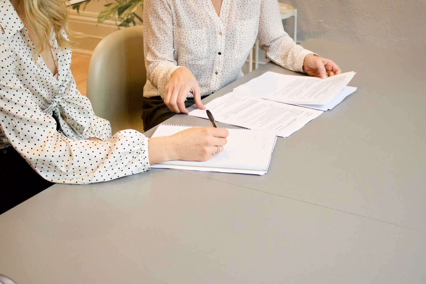 Nanda & Associate Lawyers Canada - A person signing a contract while another person reviews it