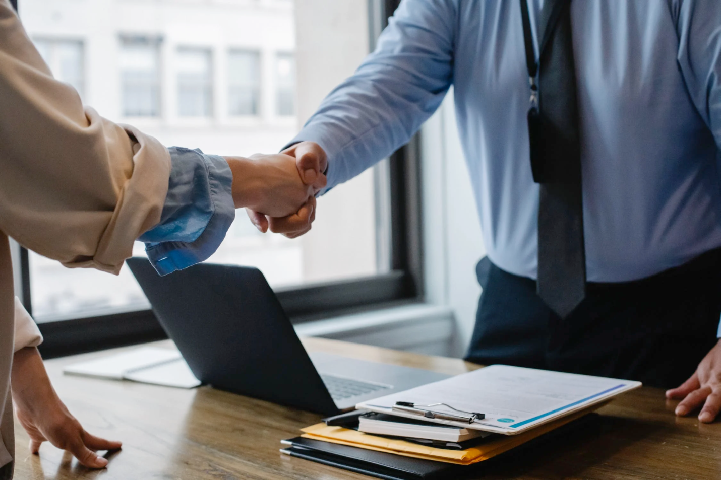 An image of two people shaking hands in the office