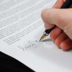 Nanda & Associate Lawyers Canada - A person signing documents