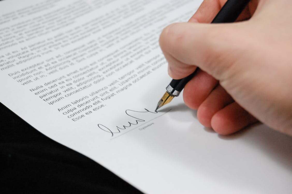 Nanda & Associate Lawyers Canada - A person signing documents