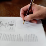Nanda & Associate Lawyers Canada - A person signing a document