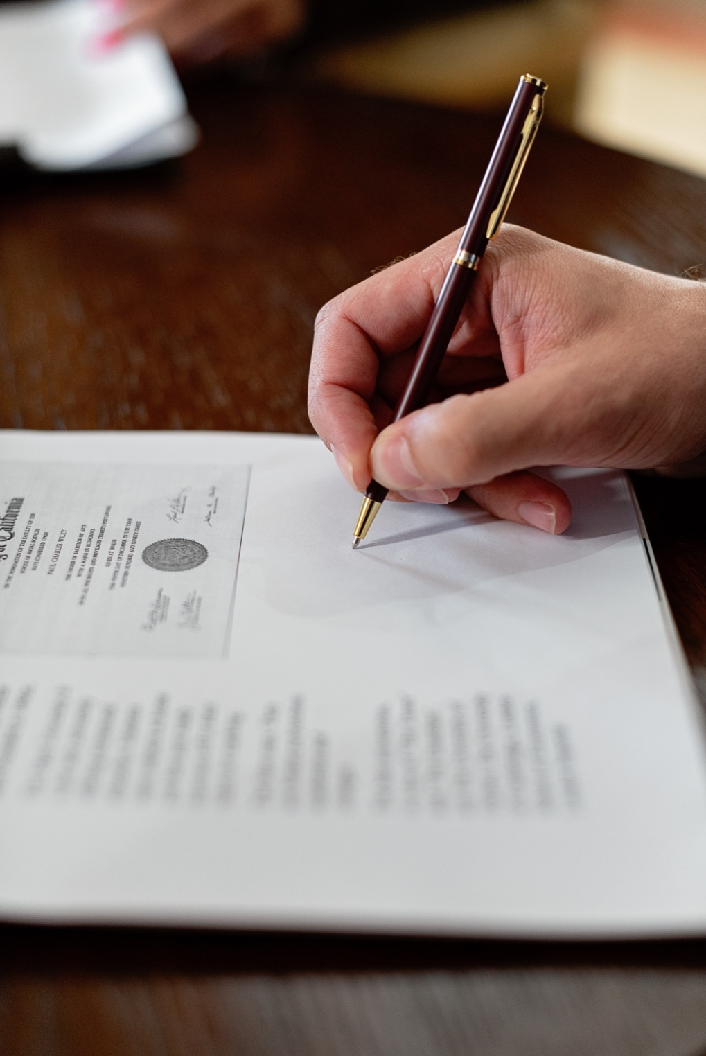 Nanda & Associate Lawyers Canada - A person signing a document