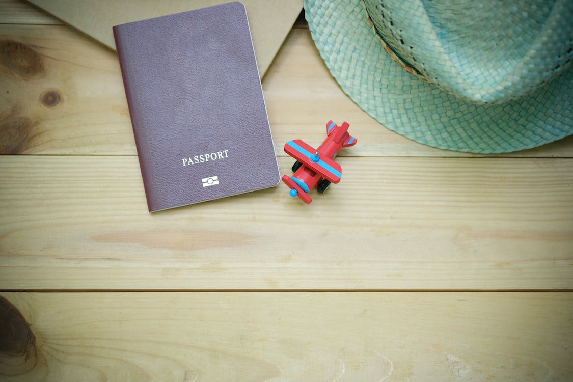 Nanda & Associate Lawyers Canada - Backside of a Canadian passport, a toy plane, and a hat