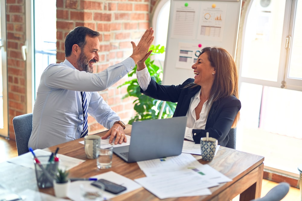 Nanda & Associate Lawyers Canada - a man and a woman high-fiving each other