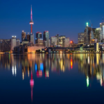 Nanda & Associate Lawyers Canada - Illuminated Canada skyline at night with city lights reflecting on the water