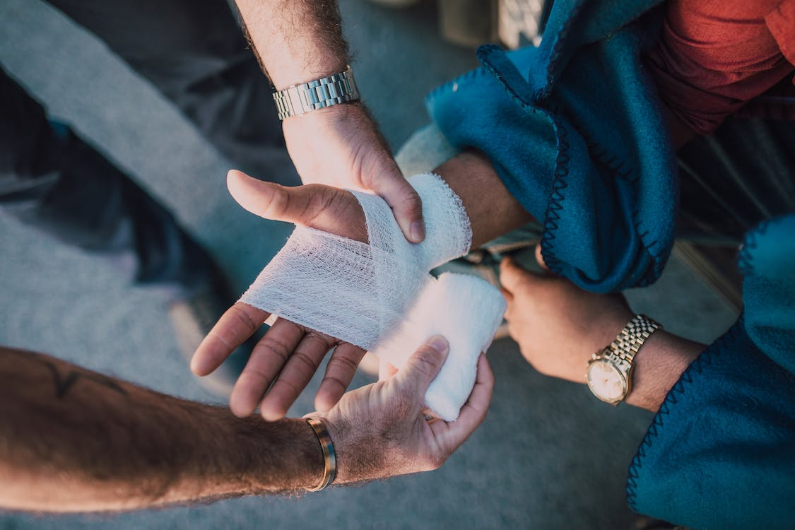 Nanda & Associate Lawyers Canada - A person carefully applying a bandage on another person's personal injury.