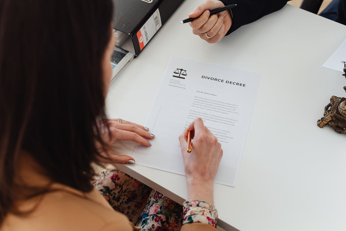 Nanda & Associate Lawyers Canada - A person signing a document
