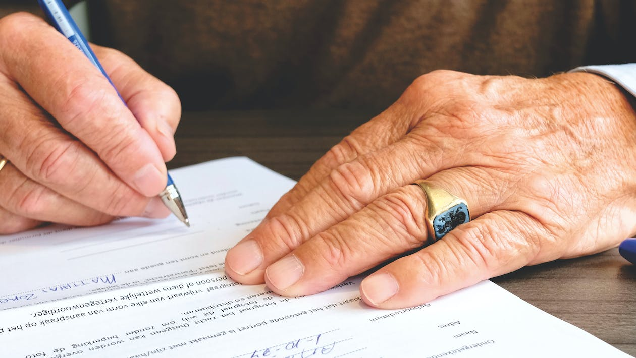 Nanda & Associate Lawyers Canada - A person signing a document