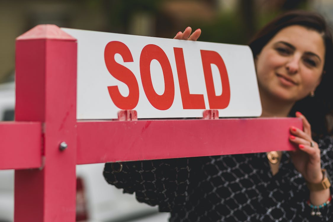 Nanda & Associate Lawyers Canada - A person near a sold sign